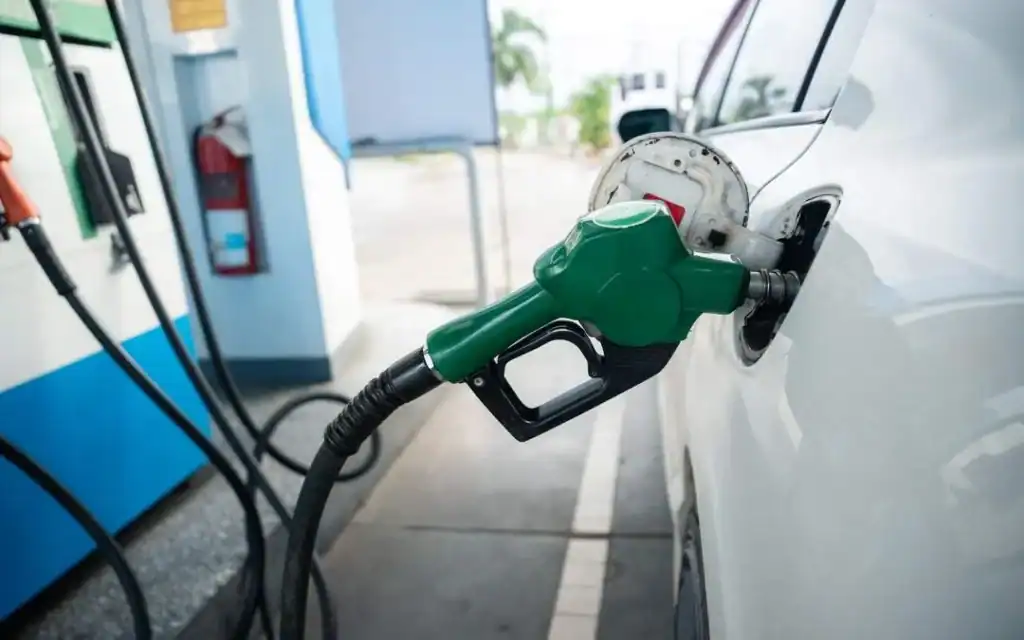 Oil Price Spike South Africa South African motorist looking concerned at a petrol pump as fuel prices increase due to Middle East conflict.