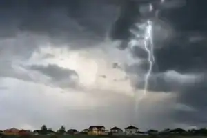 Dark storm clouds gathering over a South African road signaling severe thunderstorms and flooding.