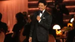 Trevor Noah on stage at the Grammy Awards 2026 alongside a screenshot of Trump’s lawsuit threat.
